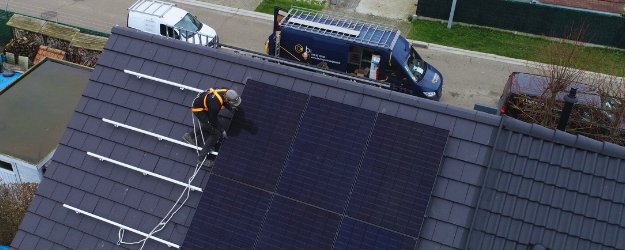 Installateur zonnepanelen Bumaco Energies aan het werk op een dak van een huis.